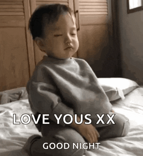 a baby is sitting on a bed and saying `` love yous xx good night '' .