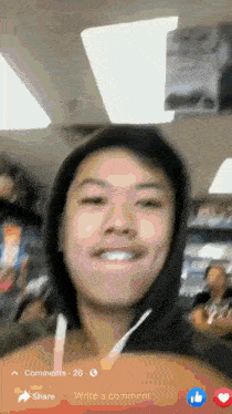 a man wearing a black hoodie is smiling in a blurry photo .