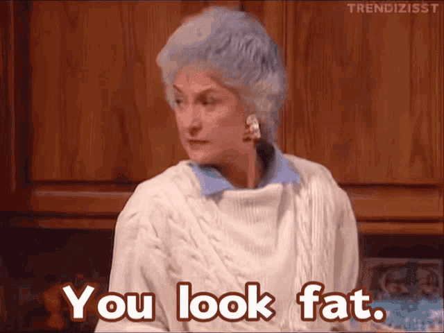 a woman in a white sweater is saying you look fat