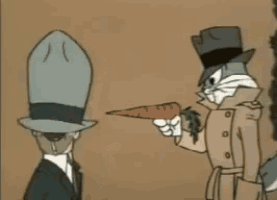 two men in suits and hats are standing next to each other and one is pointing at the other .