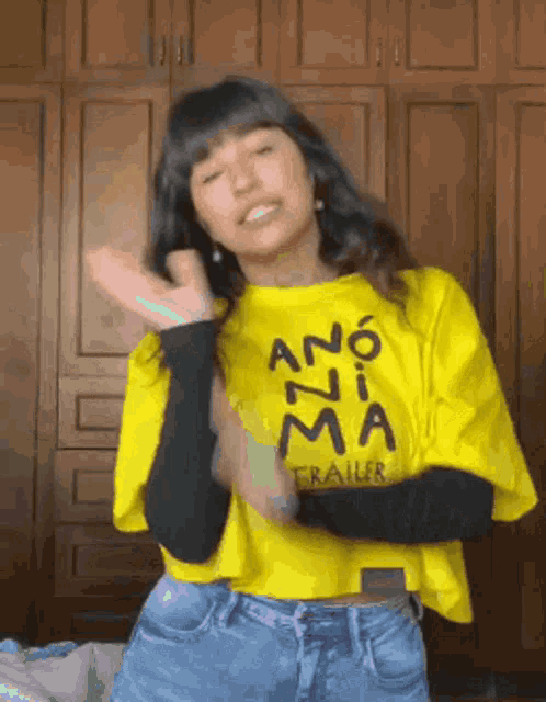 a woman wearing a yellow ano zima trailer t-shirt