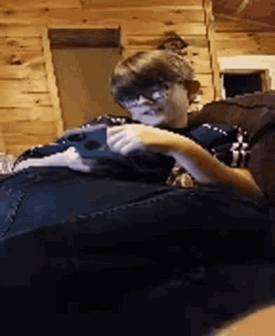 a person is sitting on a couch playing a video game