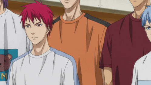 a man with red hair is wearing a white shirt with the letter m on it