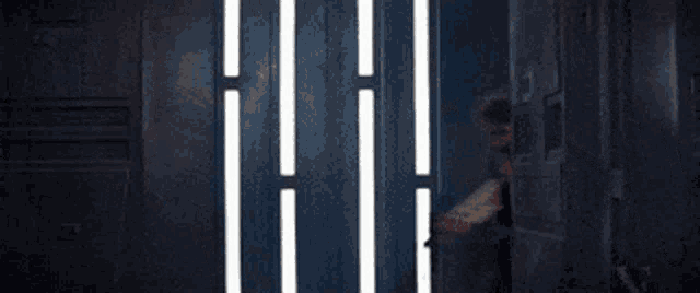 a man is holding a gun in a dark room .