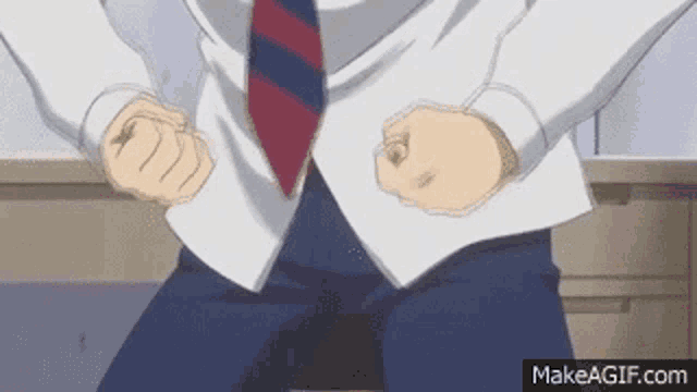 a man in a suit and tie is making a fist .
