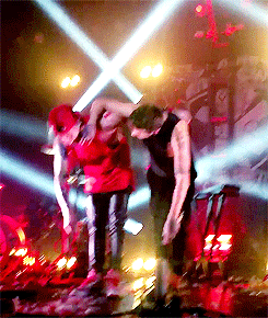 a couple of men are dancing on a stage in front of a crowd