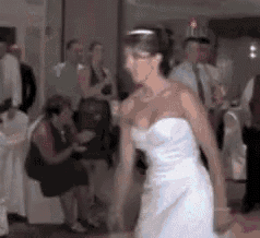 a bride in a white dress is dancing on a dance floor .