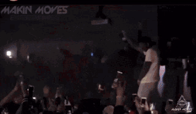 a crowd of people watching a concert with the words maniac moves written on the bottom