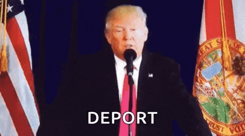 a man in a suit and tie is standing in front of a microphone with the word deport written on it .