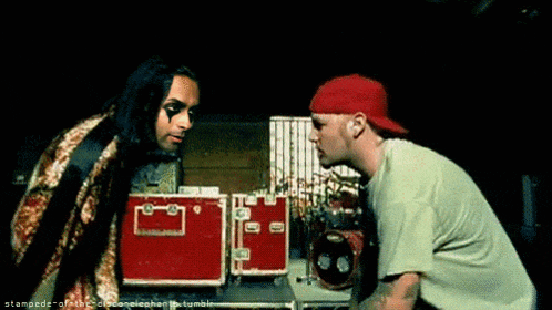 two men are standing next to each other and one has a red hat