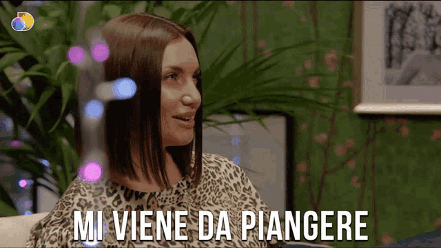 a woman sitting on a couch with the words mi viene da piangere below her