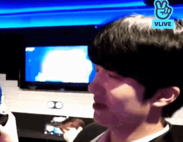 a close up of a person 's face with a vlive sticker on his head