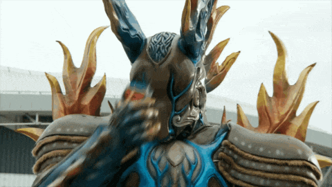 a statue of a monster with horns and a blue stripe on the back