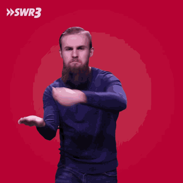 a man with a beard is throwing something in front of a red background with the letters swr3 on it