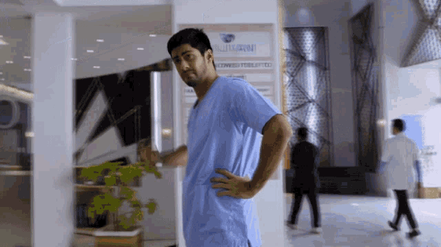 a man in a scrub is standing in front of a sign that says " surgical "