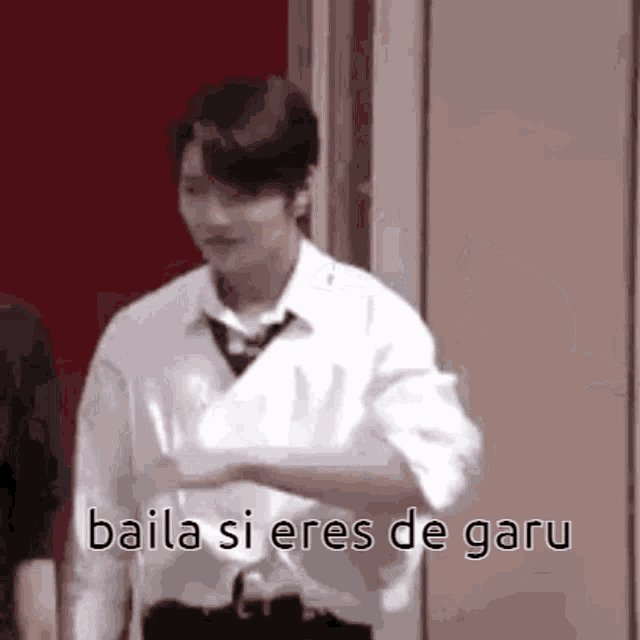 a man in a white shirt and tie is dancing in front of a door .
