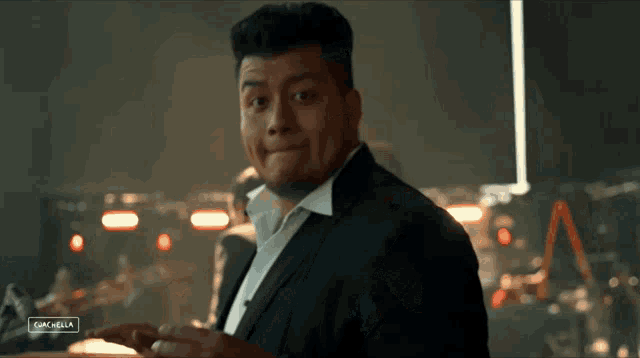 a man in a suit is giving the peace sign