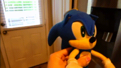 a person is holding a stuffed sonic the hedgehog in their hands