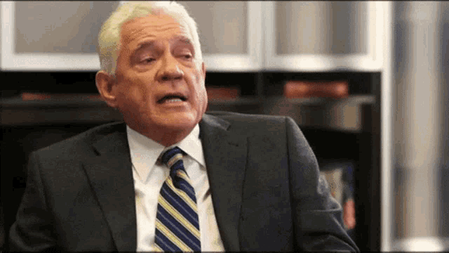 a man in a suit and tie making a face