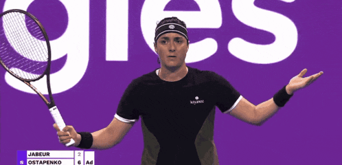 a person holding a tennis racquet in front of a sign that says ' gies '