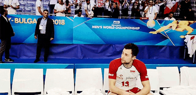 a man sitting in front of a banner that says men 's world championship on it
