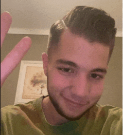 a young man with a beard is smiling and giving the peace sign