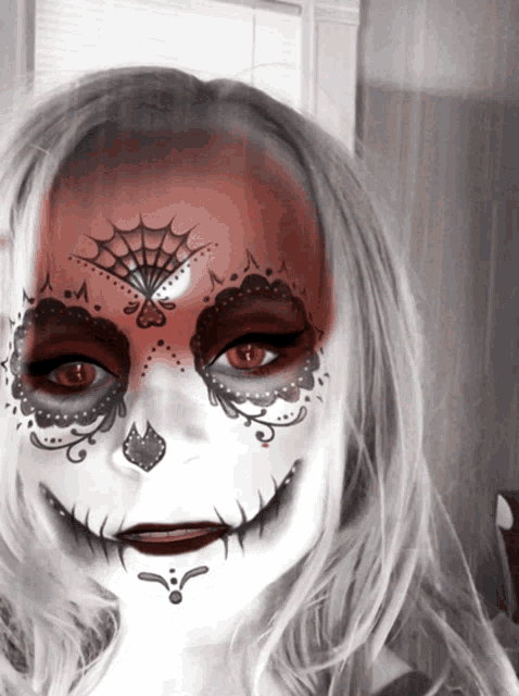 a girl with day of the dead face paint on her face
