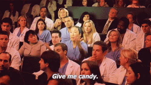 a crowd of doctors and nurses sitting in a lecture hall with the words " give me candy " on the bottom