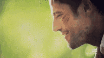 a close up of a man 's face with a beard and a green background .