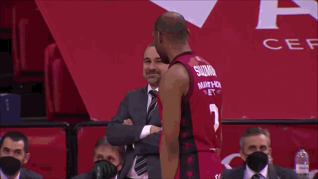 a basketball player wearing a red jersey that says ' miami ' on the front