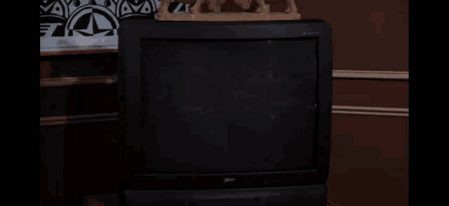 a man in a blue shirt sits in a chair holding a remote control