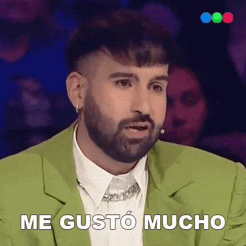 a man with a beard is wearing a green jacket and says me gusto mucho