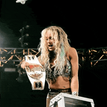 a female wrestler holds a belt that says intercontinental heavyweight champion