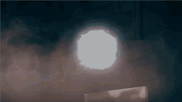 a light shines through a hole in the wall
