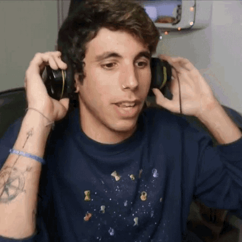 a young man wearing headphones and a sweatshirt with gummy bears on it