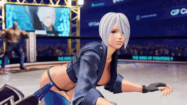 a woman in a wrestling ring with a sign that says the king of fighters in the background