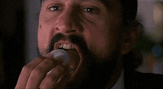 a close up of a man with a beard and mustache holding a cell phone .