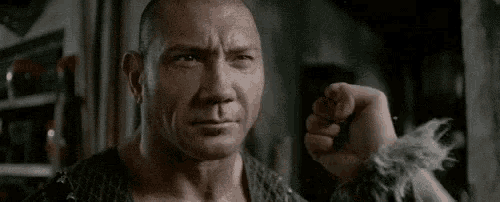 a man is holding his fist up in the air in a close up of his face .