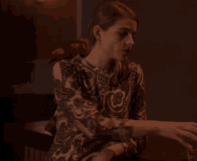 a woman in a paisley dress drinking from a glass