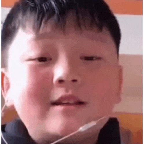 a young boy is making a funny face with his mouth open .