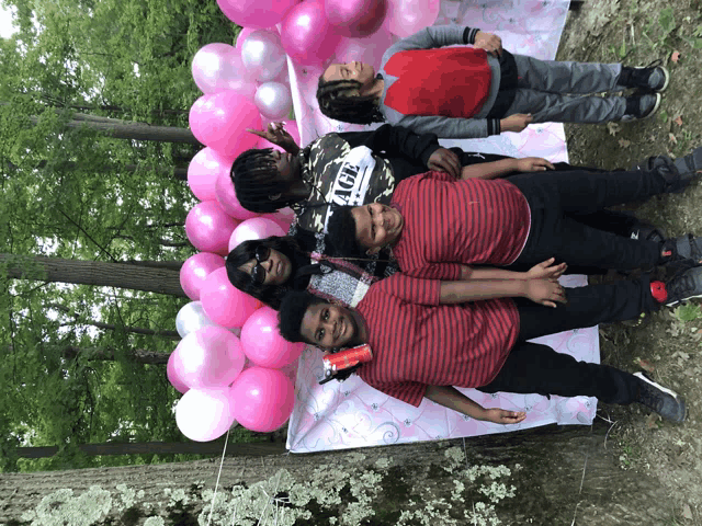 a group of children pose in front of pink balloons and a sign that says aol