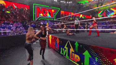 a group of women wrestling in a ring with a sign that says nxt