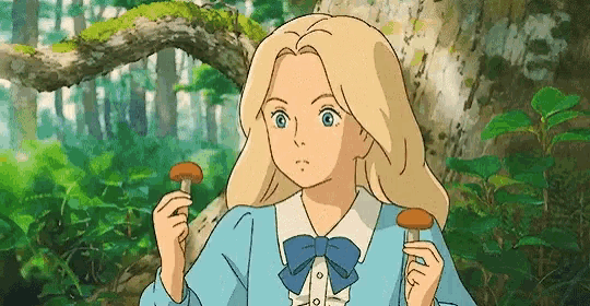 a girl in a blue dress is holding a mushroom in her hand