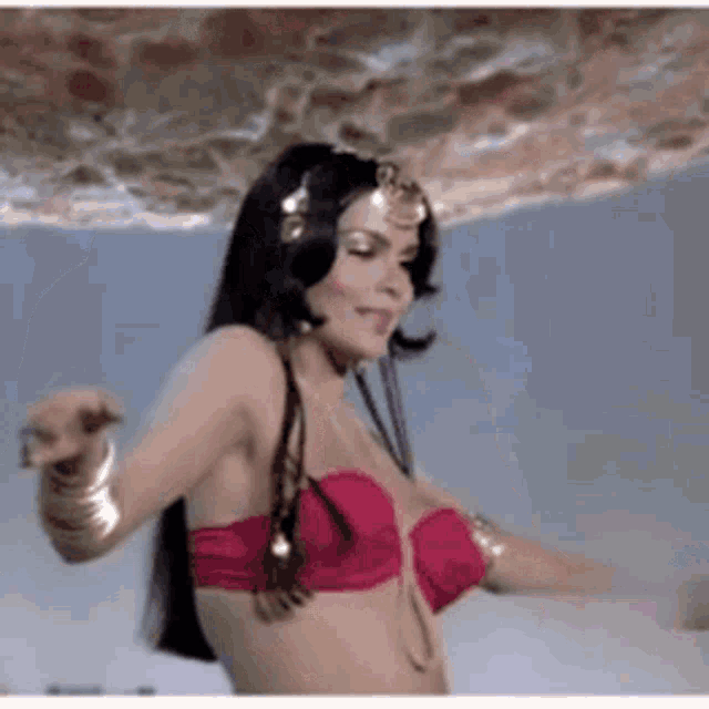 a woman in a red bikini is dancing under a ceiling .