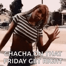 a woman in a striped crop top is dancing on a sidewalk .