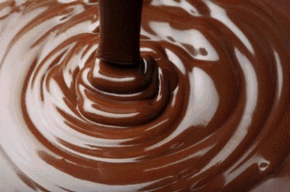 a swirl of chocolate is being poured into a cup
