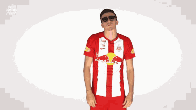 a man wearing a red and white jersey with a red bull on the front