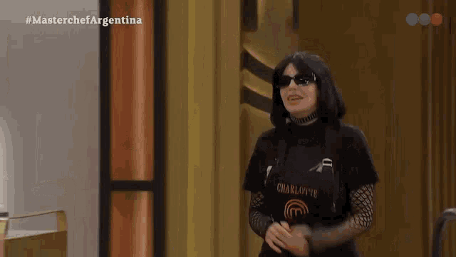 a woman wearing sunglasses and a black shirt that says charlotte on it