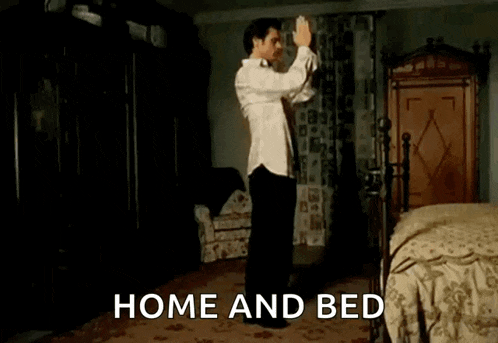 a shirtless man is dancing with a dog in front of a bed with the words home and bed behind him