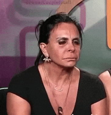 a woman is crying and making a funny face while wearing a black shirt .